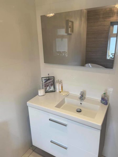White vanity unit with inset basin and chrome mixer tap