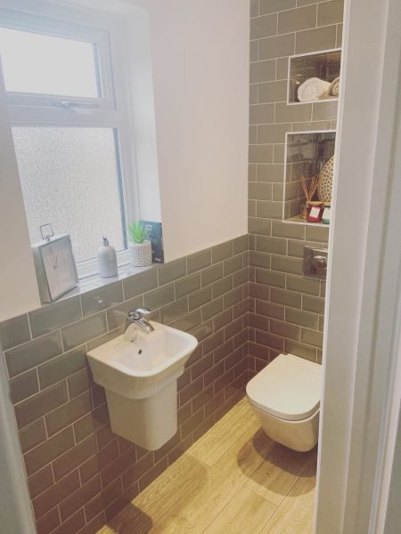 Cloakroom with wall-hung basin, back-to-wall toilet and grey metro tiling